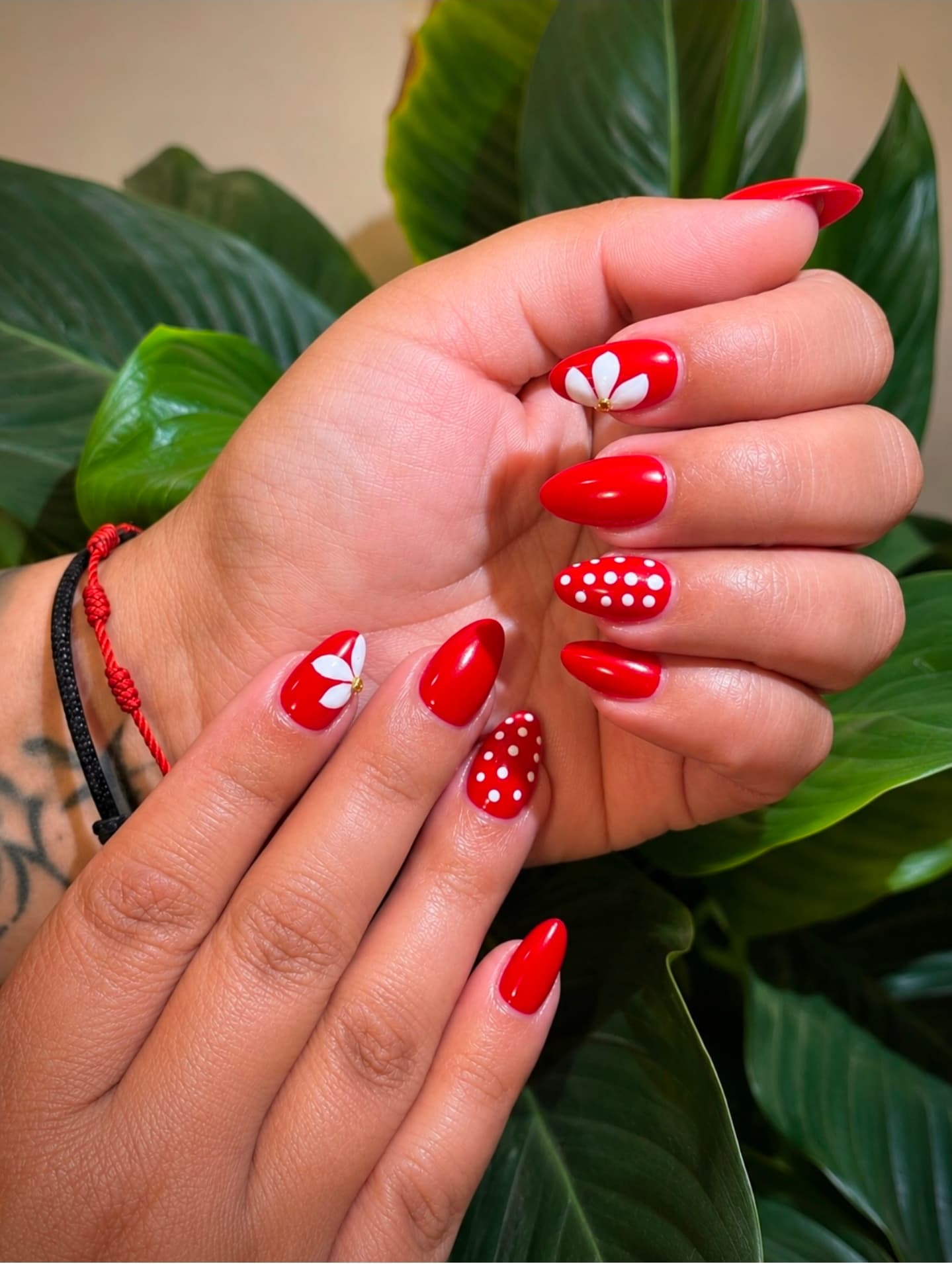 Uñas almendradas en rojo con flores blancas en relieve y lunares